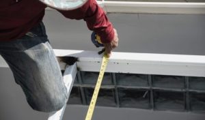 onsite construction worker with steel roof structure installation, residential building contractor job